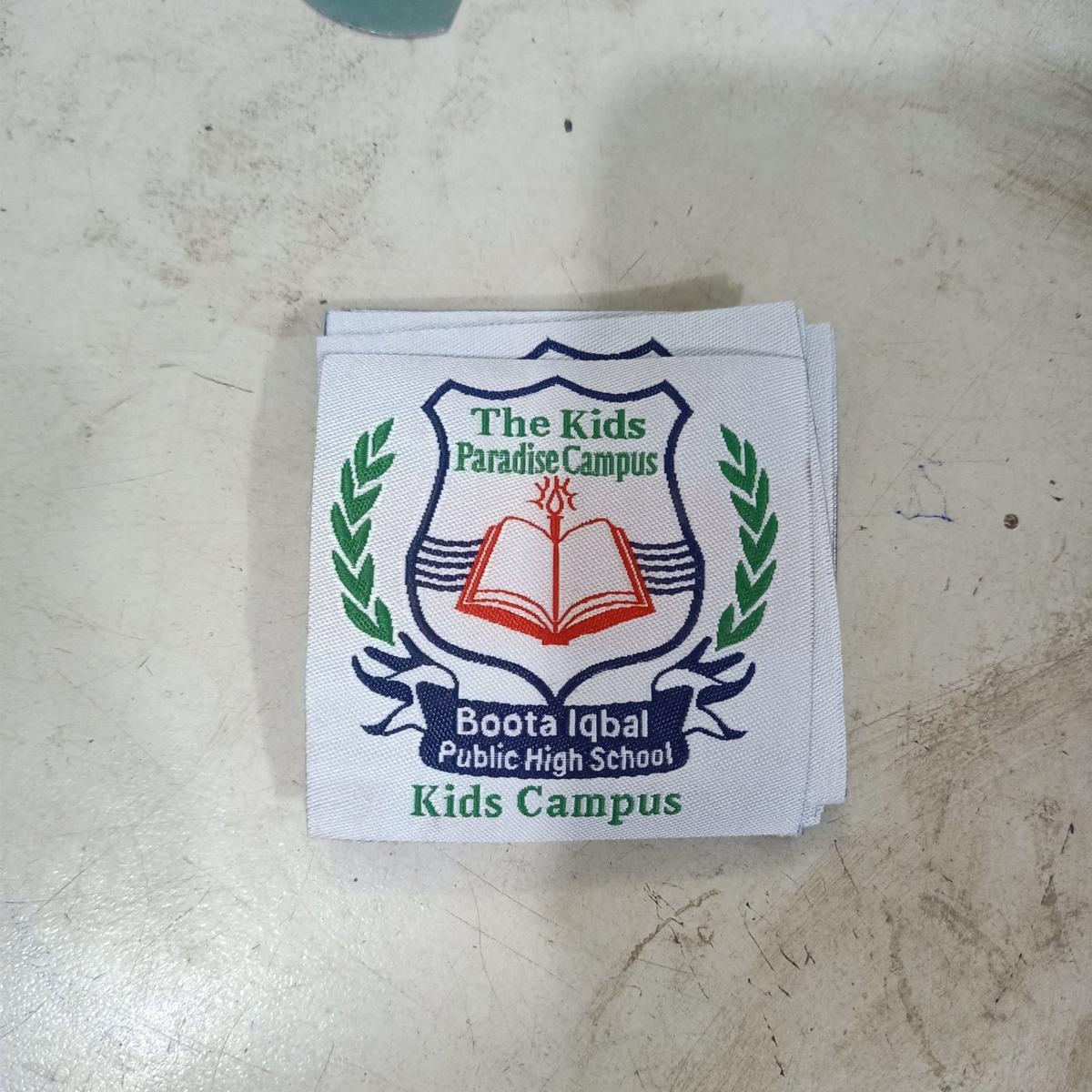 Woven school badge for The Kids Paradise Campus, shield crest